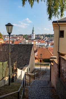 Narrow picturesque street with colorful buildings in historic center in medieval city Trebic, aisle in renaissance and baroque historical buildings at jewish quarter. Czech Republic