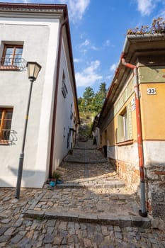 Narrow picturesque street with colorful buildings in historic center in medieval city Trebic, aisle in renaissance and baroque historical buildings at jewish quarter. Czech Republic