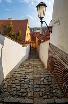 Narrow picturesque street with colorful buildings in historic center in medieval city Trebic, aisle in renaissance and baroque historical buildings at jewish quarter. Czech Republic