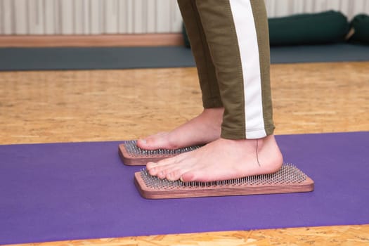 practice of standing on nails. Close-up of a yoga man standing on a sadhu board with sharp nails. Wooden sadhu board with nails for sadhu practice