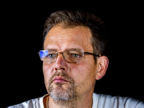 Portrait of a bearded man with glasses for vision. A man with a gray beard. Portrait. Glasses for sight. The face of an adult. The age of the people. Black background. Fathers day.