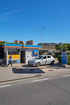 Civitavecchia. Italia  - December 27, 2024:  Urban gas station in Civitavecchia, Italy, with a parked car. Modern IP station with blue sky and urban buildings, showing the concept of urban refueling.