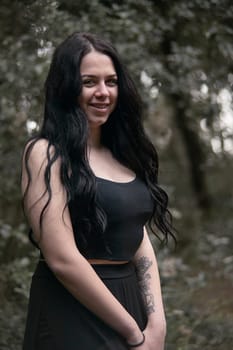A brunette young Girl In A Black Dress alone In The Forest