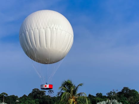 Large white air balloon in the sky above palm trees, Langkawi, Kuah, Malaysia, copy space
