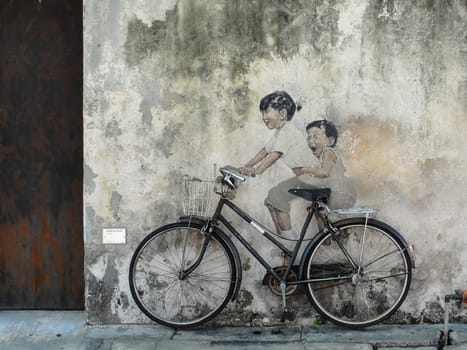 Little Children on a Bicycle street art on wall by Lithuanian artist Ernest Zacharevic in George Town, Penang, Malaysia, travel photo