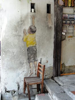 Street art titled Reaching Up by Ernest Zacharevic in Georgetown, Penang, Malaysia, travel photo