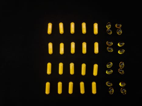 Yellow capsules are laid out on a black background in the form of a reception schedule for a month