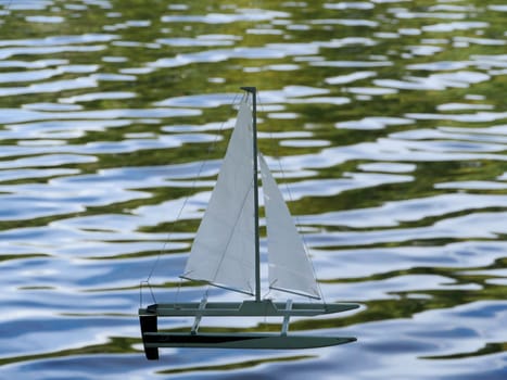 small sailing catamaran on the waves children's toy sailing