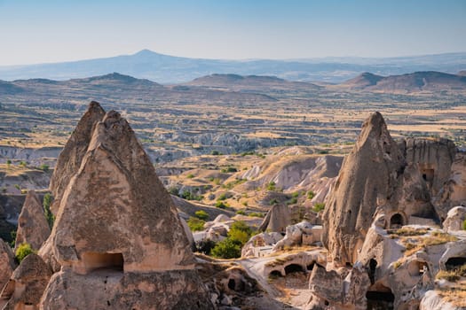 beautiful sunset landscape in Cappadocia valley with ancient cave houses in the foreground