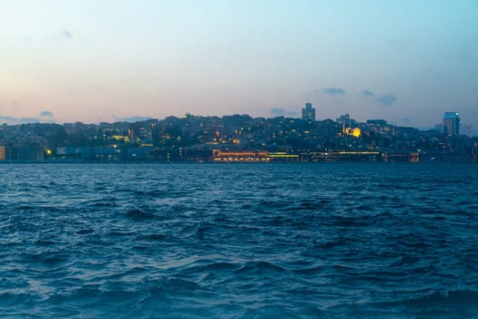 sunset panorama of the Istanbul city skyline over the Golden Horn with Bosphorus waves in the foreground