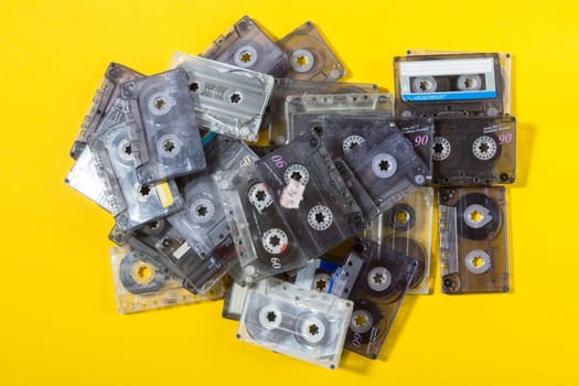 pile of audio compact cassettes on a yellow background