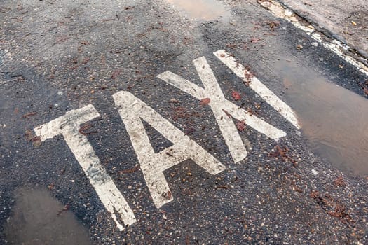 taxi sign painted with white color on street