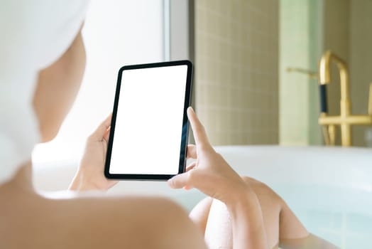 Using digital tablet, Women holding digital tablet while soaking in the bathtub in moring