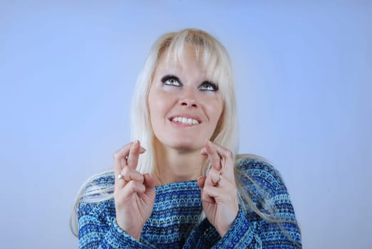 Young blond woman fingers crossed