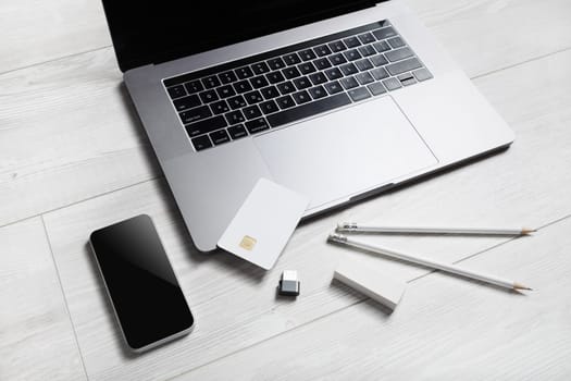 Gadgets and supplies. Laptop, smartphone, credit card, pencils, eraser and flash drive. Online shopping concept.