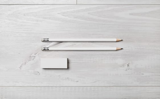 Two blank pencils and eraser on wooden background. Flat lay.