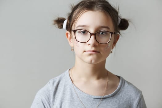 Studio portrait of a teenage girl wearing glasses.
