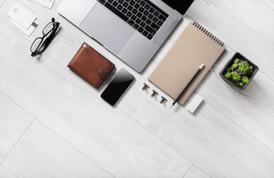 Business office supplies and laptop on wooden background. Copy space for text. Flat lay.