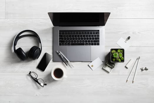 Office workspace with supplies and gadgets on wooden background. Flat lay.