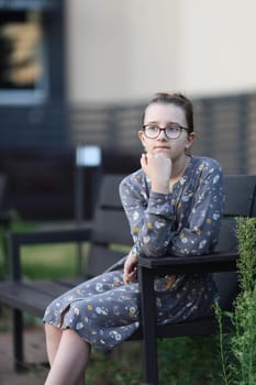 Girl sitting on bench. Pensive teen girl. Selective focus.