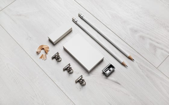 Blank business card, pencils, eraser and sharpener on wooden background. Blank branding identity set.