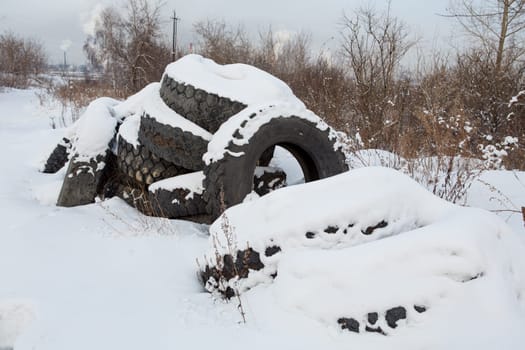 old discarded tires in the snow.environmental pollution.