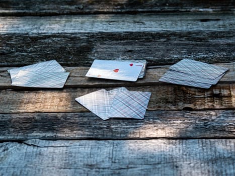 Playing card ace of hearts on a wooden table. A deck of playing cards. Gambling. Gaming business. A place for gambling. Rest and leisure.