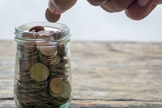 Save money and account banking for finance concept, Hand with coin on blurred background