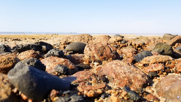 Sea pebbles background. Natural seashore coast textured stones, selective focus, shallow depth of field