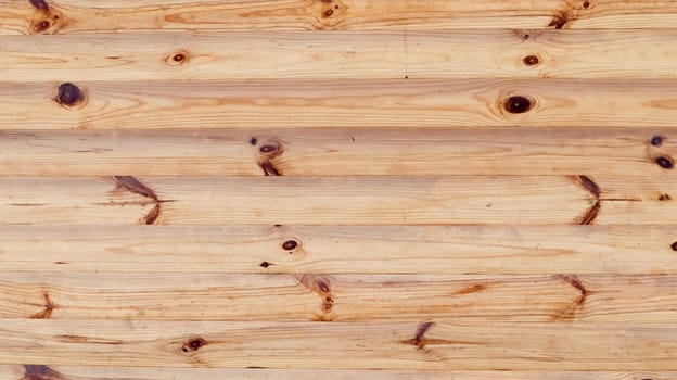 Brown rustic wood texture background. Natural background pattern from a log wall. Facade of a log house, copy space. A board with lots of horizontal wooden logs