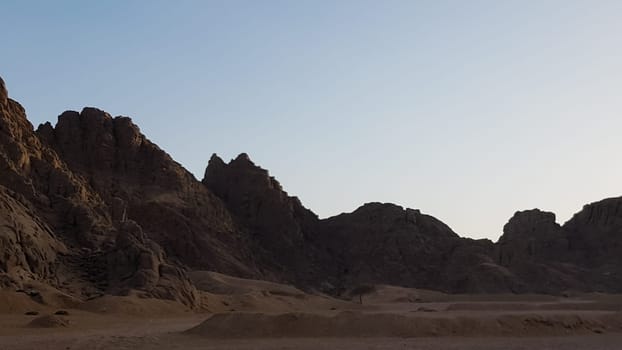 Sunset in the desert in Egypt. Mountain cliff in the desert at sunset. Nature and landscape