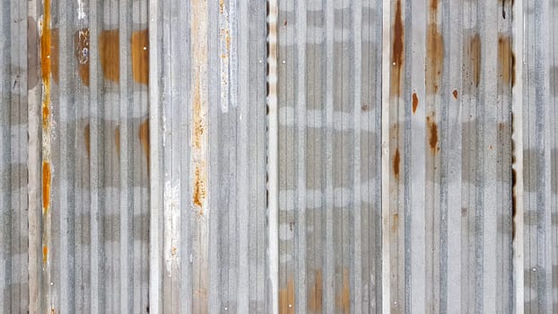A rusty and weathered piece of corrugated metal. Corroded galvanized iron sheet. old zinc wall background