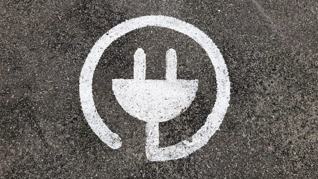 Electric charger symbol for cars, in a public parking.