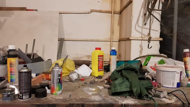 Ukraine, Kiev - May 09, 2020: Work tools on the board and in the workshop. Workshop scene. A lot of old tools on a dirty desktop. The concept of carpentry and painting