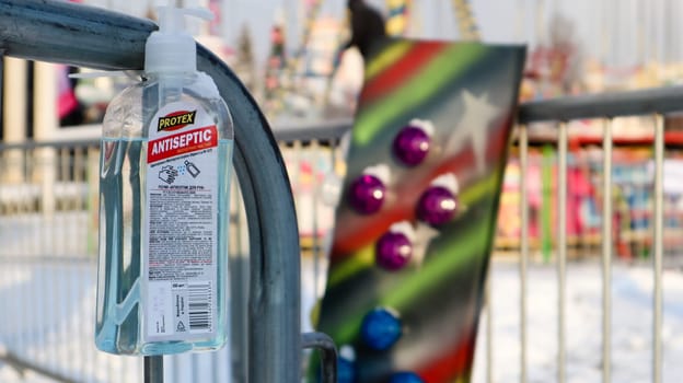 Disinfectant near the ticket booth in an amusement park. Close-up of a disinfectant with a label that has English text for visitors to the amusement park. Ukraine, Kiev - January 14, 2021