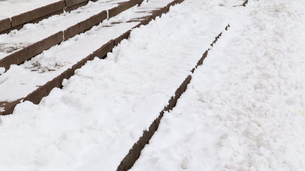 Snow covered slippery concrete stairs. First snow on granite stone steps