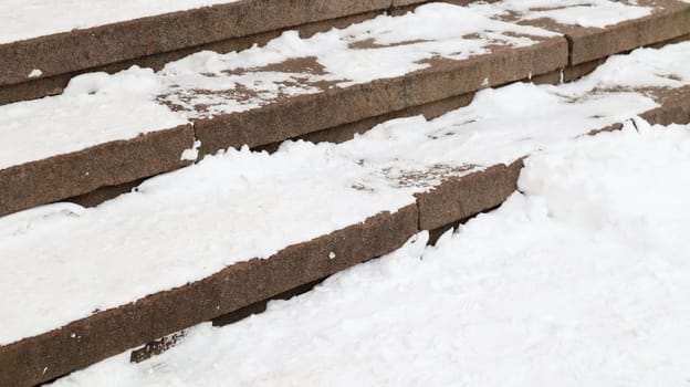 Snow covered slippery concrete stairs. First snow on granite stone steps