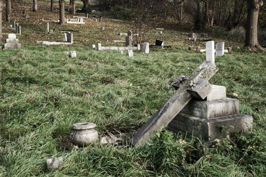 A deserted overgrown graveyard with grey stone headstones