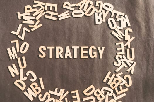 Strategy Word In Wooden Cube Alphabet Letters Top View On A rustic paper Background.