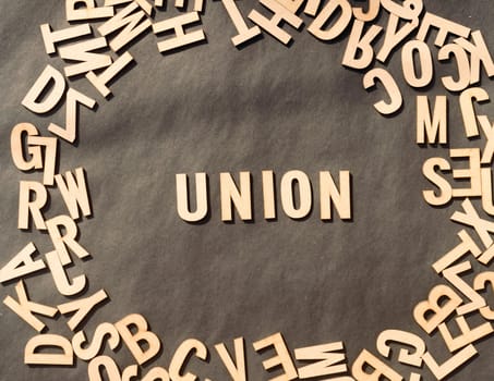 Union Word In Wooden Cube Alphabet Letters Top View On A rustic paper Background.
