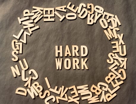 Work Hard Word In Wooden Cube Alphabet Letters Top View On A rustic paper Background.
