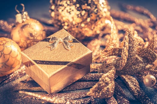 Christmas ornaments with small present in golden tones