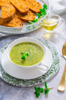 Homemade zucchini soup with tomato ciabatta bread and herbs