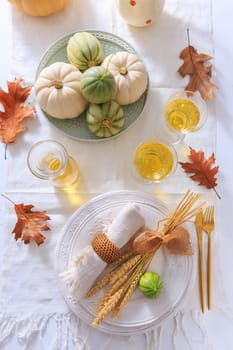 Place settings for Thanksgiving with pumpkins, ears and apple wine