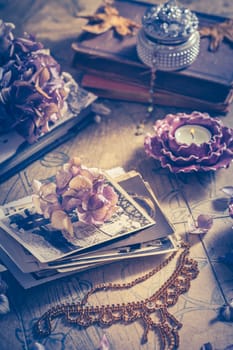 Memories - old family photo album with necklace, old books and dried flowers and candles