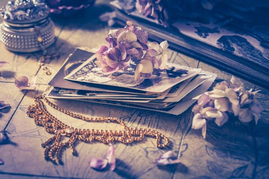 Memories - old family photo album with necklace, old books and dried flowers and candles