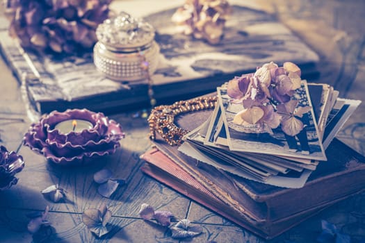 Memories - old family photo album with necklace, old books and dried flowers and candles