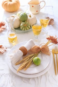 Place settings for Thanksgiving with pumpkins, ears and apple wine