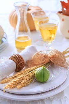 Place settings for Thanksgiving with pumpkins, ears and apple wine