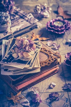 Memories - old family photo album with necklace, old books and dried flowers and candles